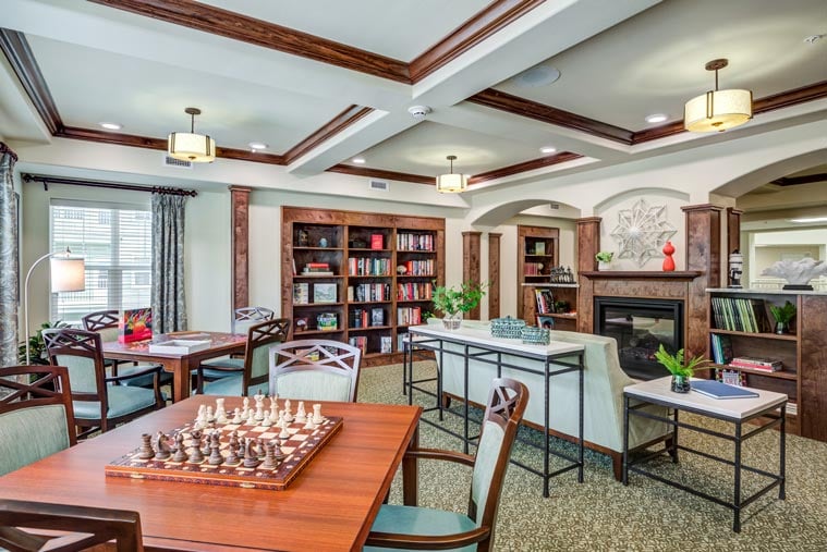 The library at Sterling Heights with shelves of books and comfortable seating